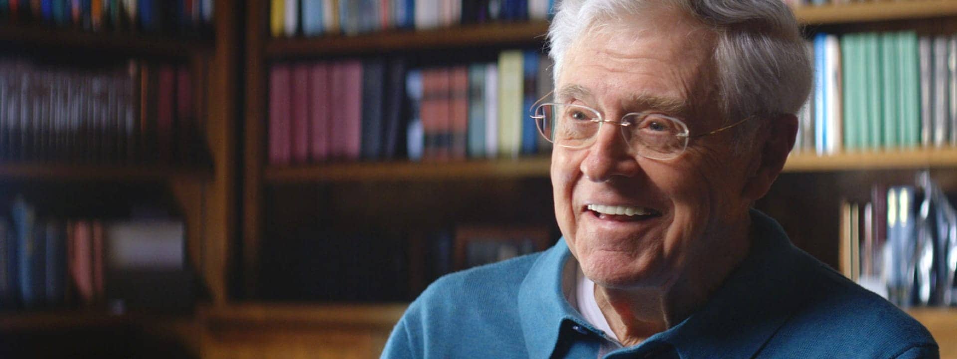 Charles Koch in front of a book shelf